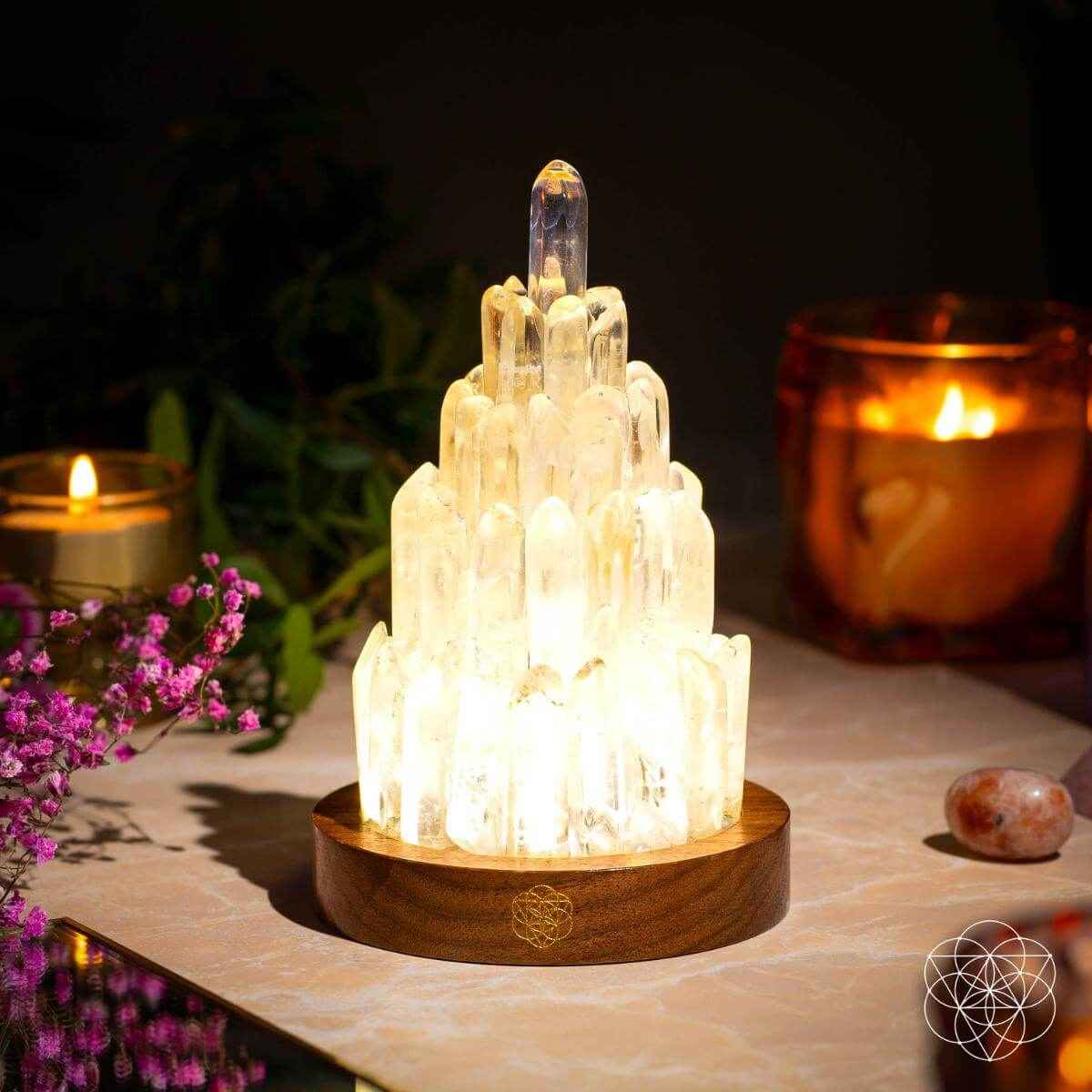 Clear quartz manifestation tower lamp with warm-glowing crystal tower on wooden base