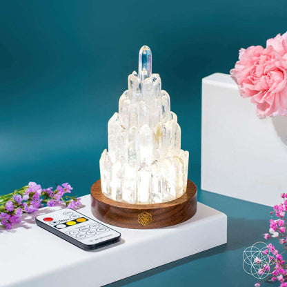Clear quartz manifestation tower lamp showing tall crystal clusters on wooden base