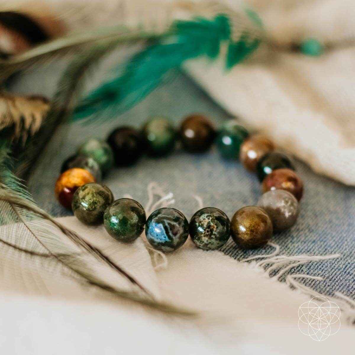 Beaded gemstone bracelet with green and brown round stones and blue-gray highlights
