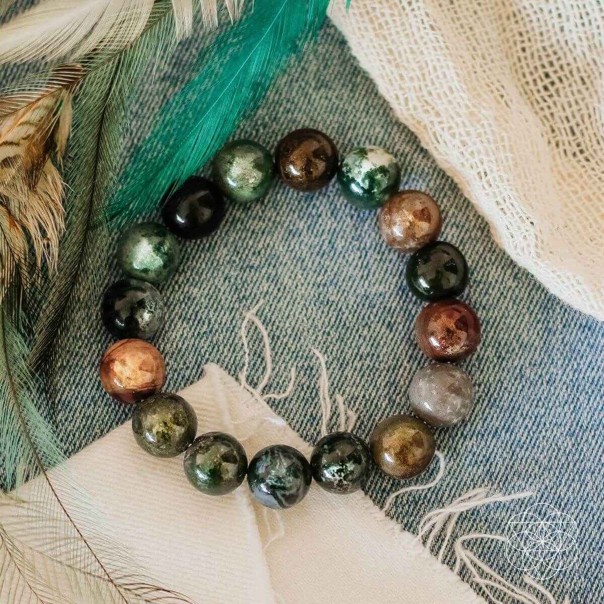 Gemstone bead bracelet with dark green, brown, and silver-toned round beads