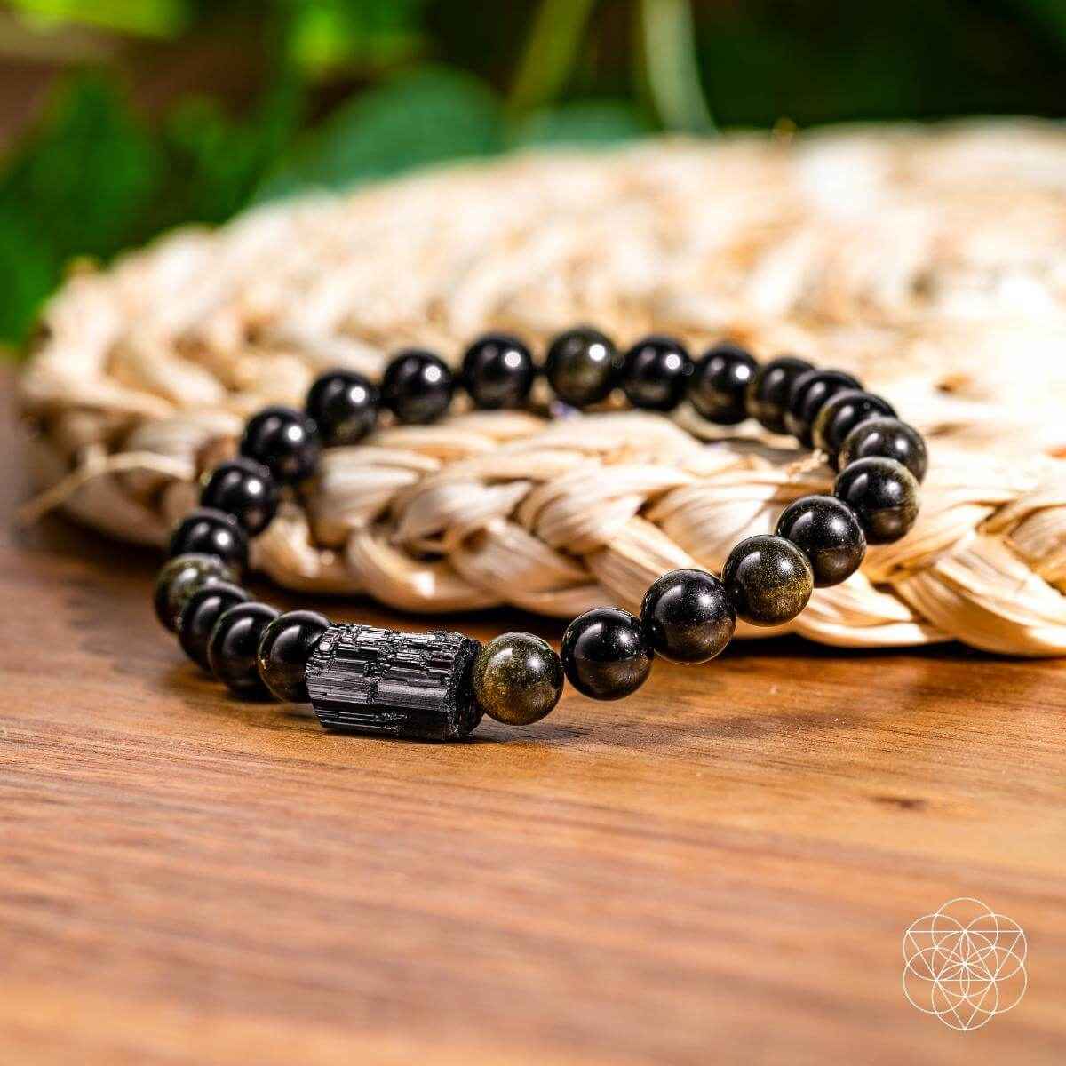 Energy protection beaded bracelet with dark round beads and rectangular centerpiece charm