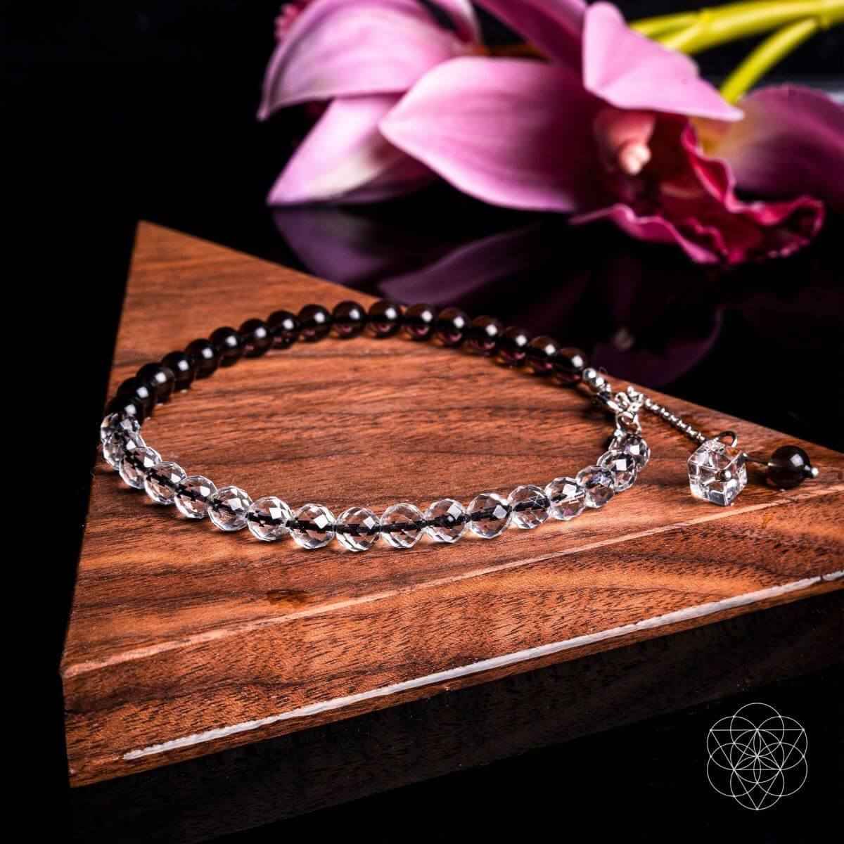 Beaded anklet with silver-tone chain, dark beads, and crystal charm toggle clasp