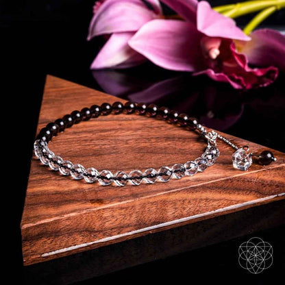 Beaded anklet with silver-tone chain, dark beads, and crystal charm toggle clasp