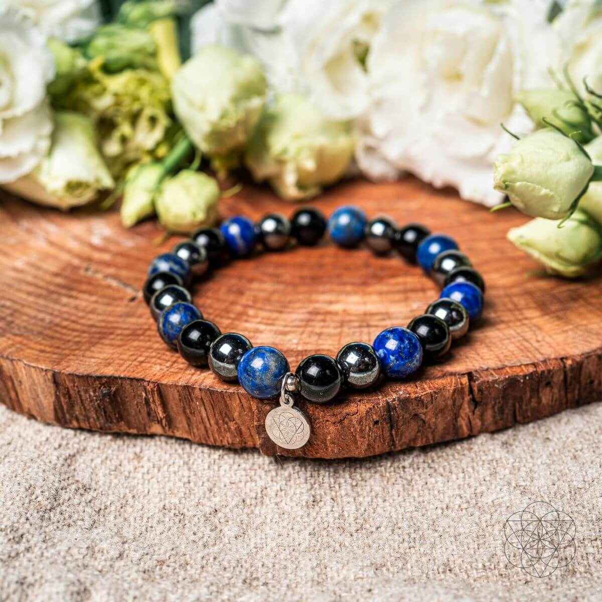 Beaded energy-shield bracelet with dark blue and black beads and round silver charm