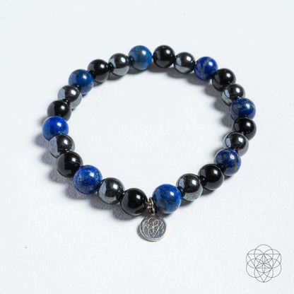 Close-up of energy-shield bracelet with dark blue and black beads and round silver charm