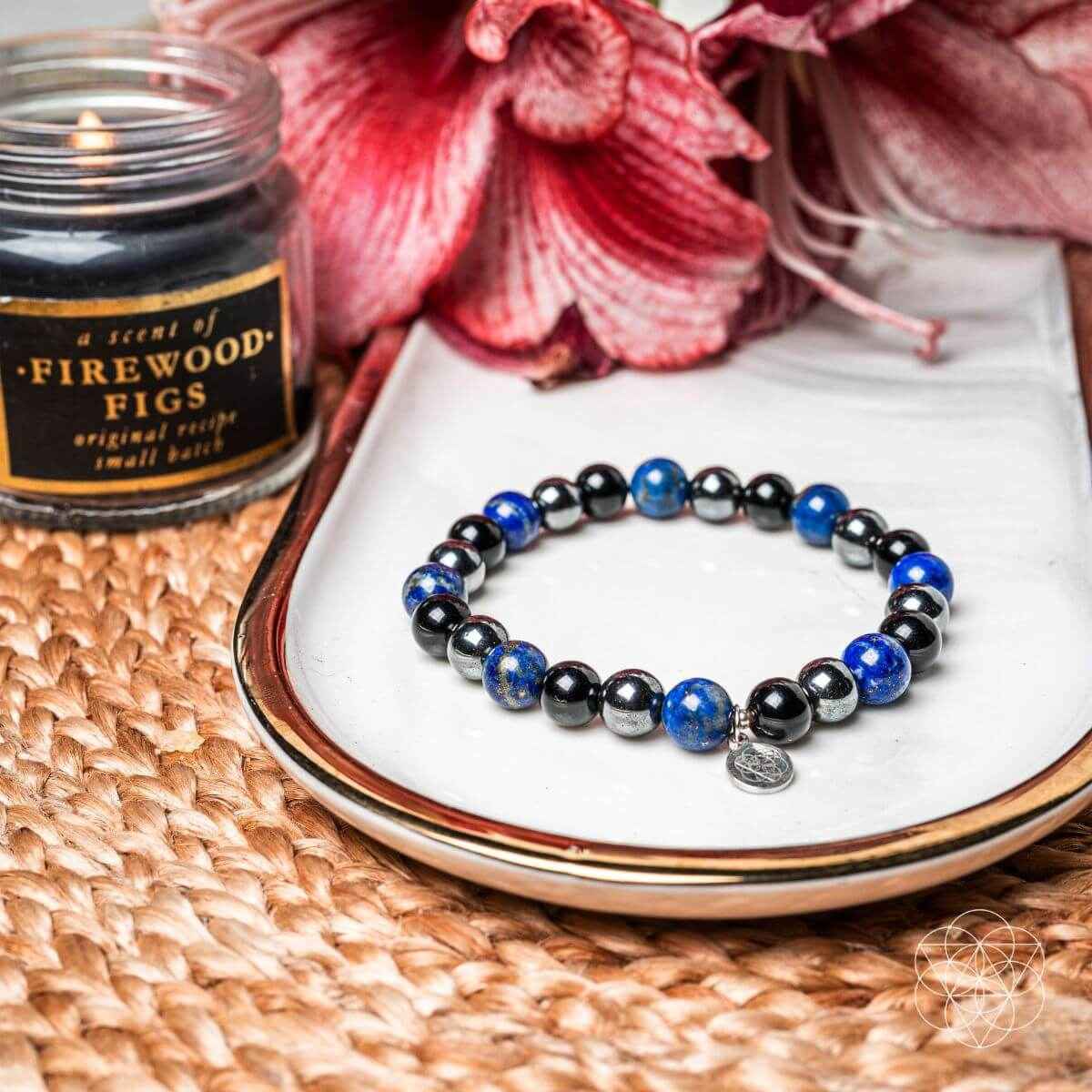 Beaded energy-shield bracelet with blue and black round beads and silver charm center