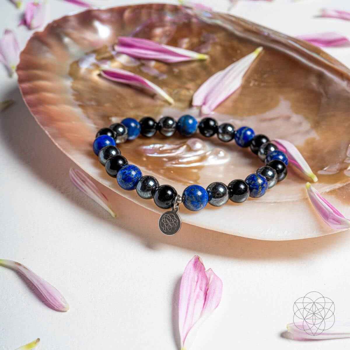Blue and black beaded energy-shield bracelet with round silver charm