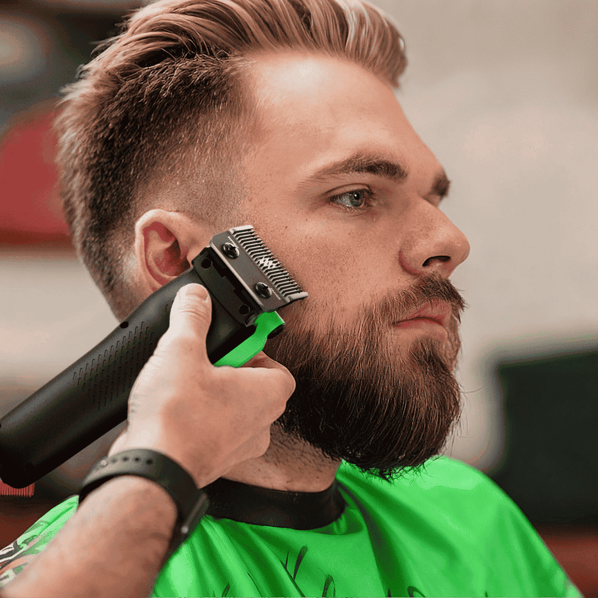 Hair clipper trimming facial hair; black and green clipper with green lever