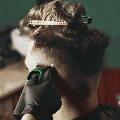 Hair clipper cutting hair at the neckline; black and green clipper