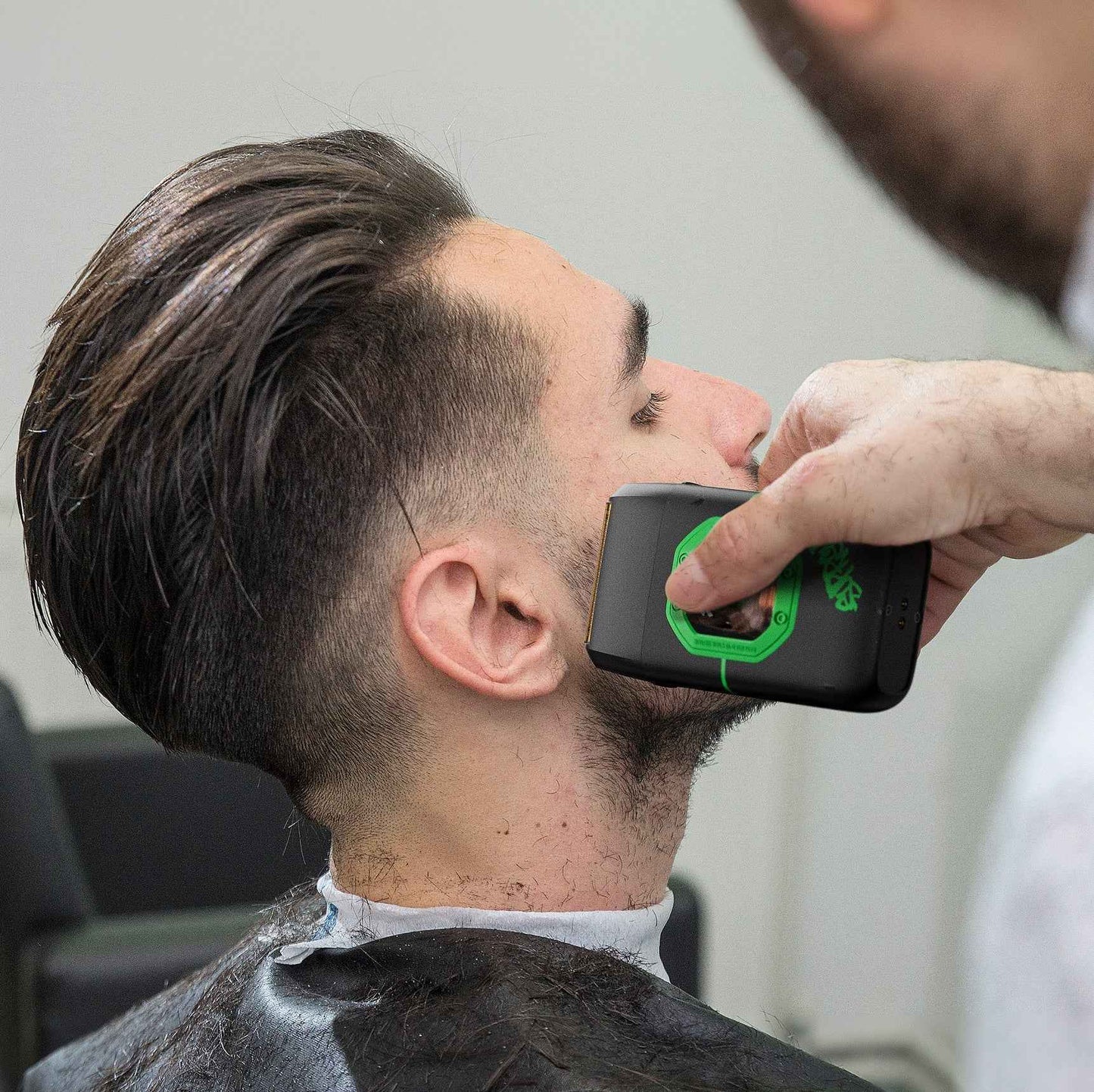 Man using a black and green foil shaver on the neck