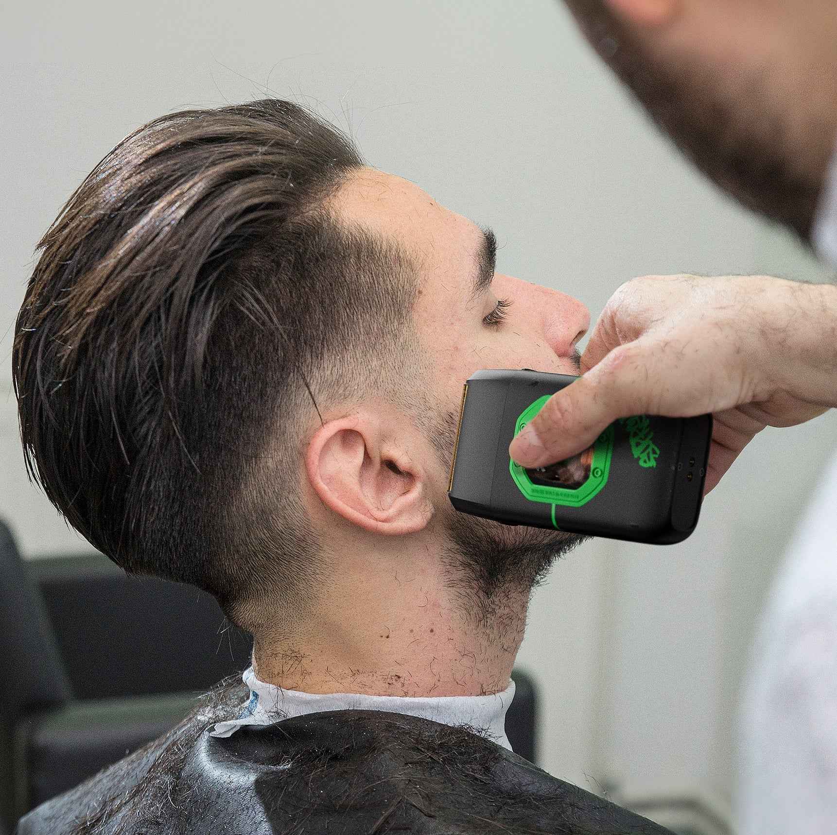Man using a black and green foil shaver on the neck