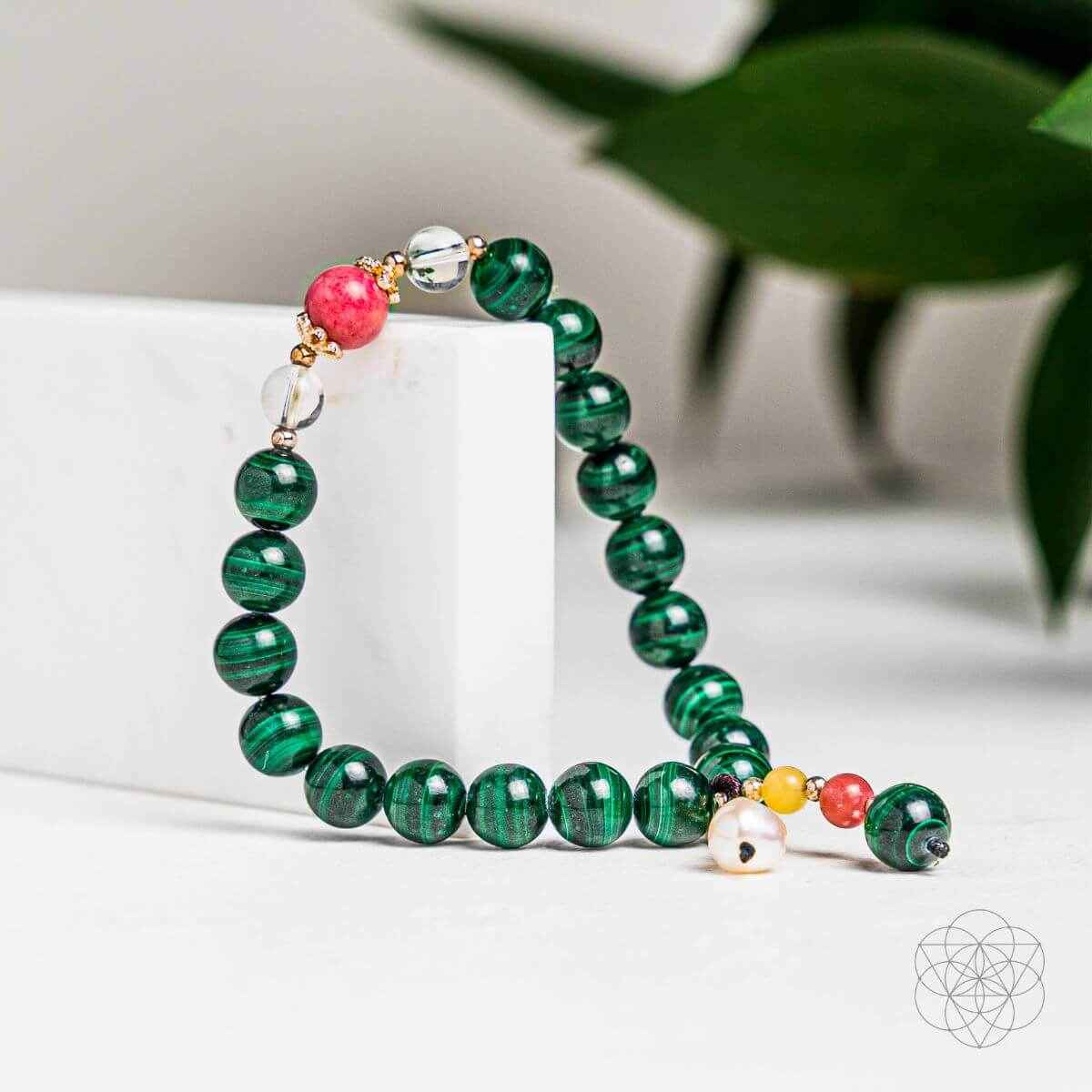 Green beaded law of attraction bracelet with pink and gold charm accents