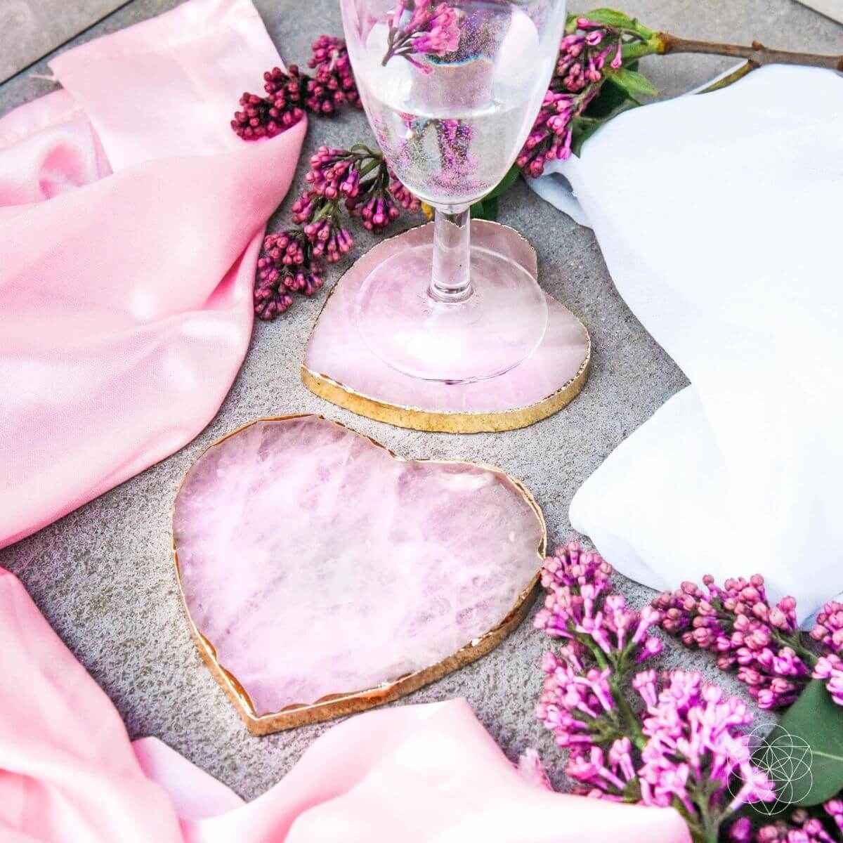 Pink heart-shaped marble coaster with gold edge; set of 2, beside a wine glass