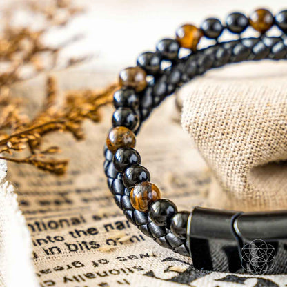 Black bead bracelet with gold-tone bead accents and rectangular metal clasp