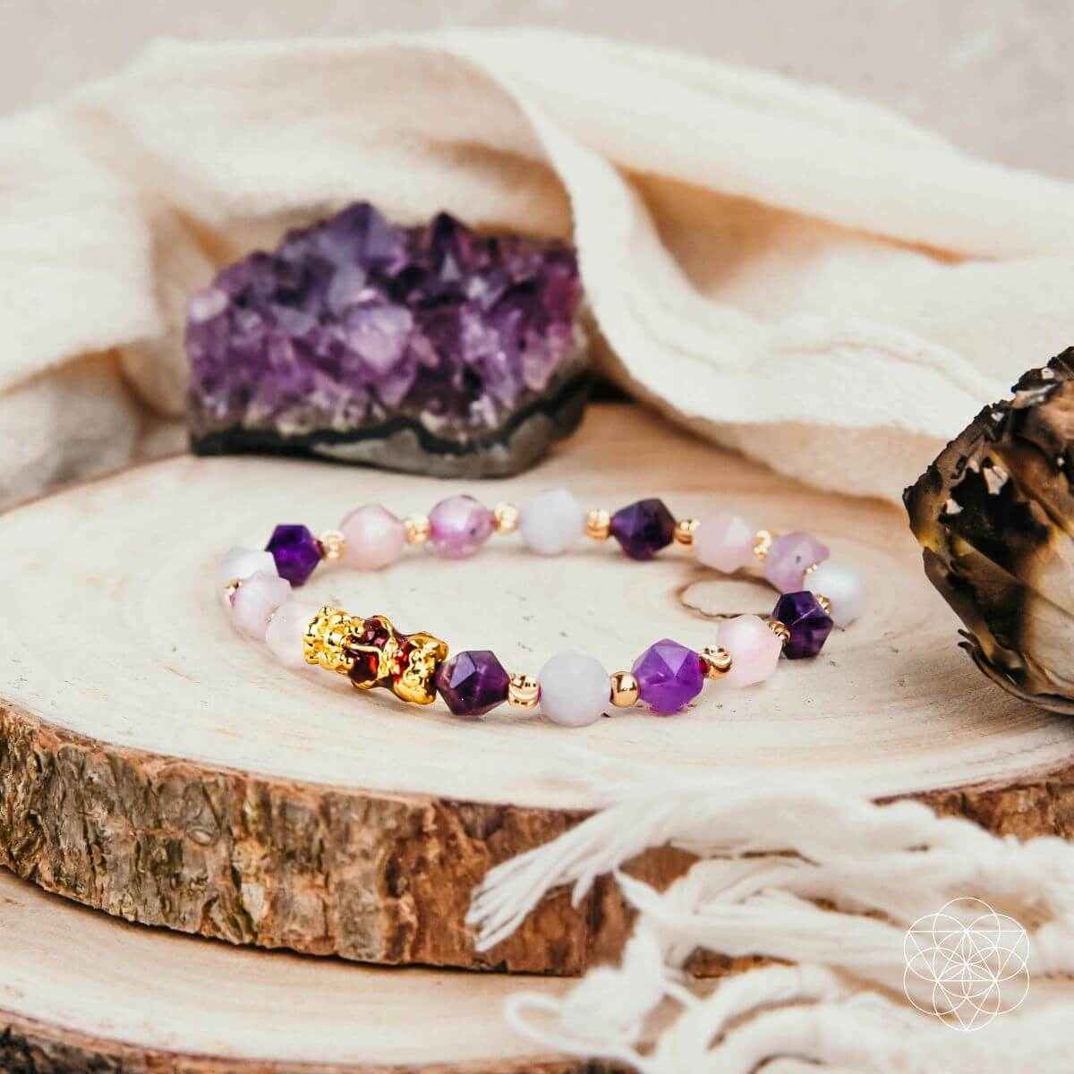 Beaded prosperity bracelet with purple and pink stones, gold spacers, central charm