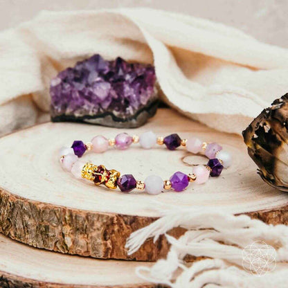 Beaded prosperity bracelet with purple and pink stones, gold spacers, central charm