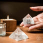 Clear crystal pyramid figurine in open hand