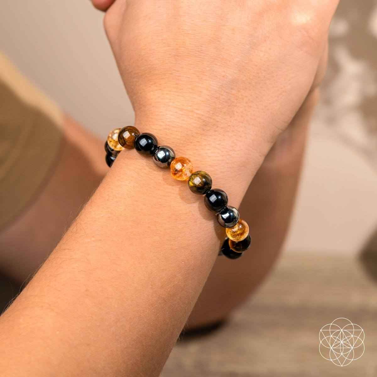 Beaded bracelet on wrist with black and amber bead pattern, stretch fit.