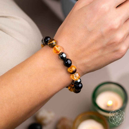 Beaded bracelet worn on wrist with black and amber beads, stretch band.