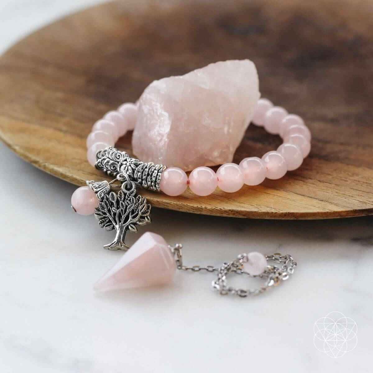 Rose quartz crystal set featuring bead bracelet, tree charm pendant, and raw stone
