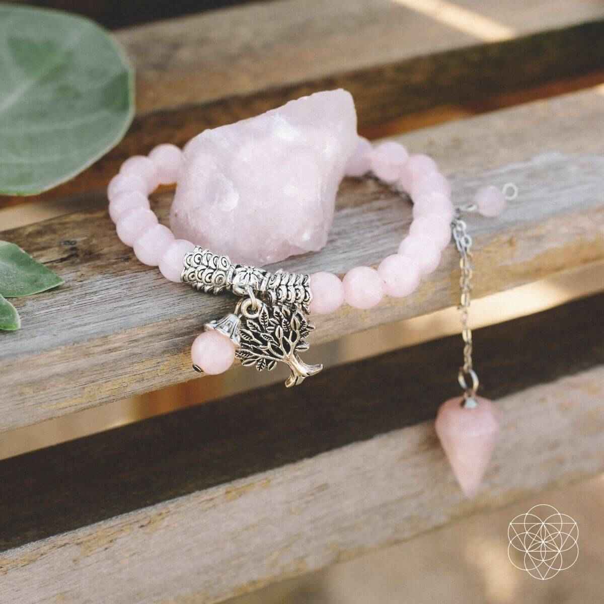 Rose quartz crystal set with pink beaded bracelet, leaf-and-tree charms, and raw crystal