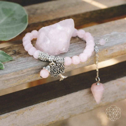 Rose quartz crystal set with pink beaded bracelet, leaf-and-tree charms, and raw crystal