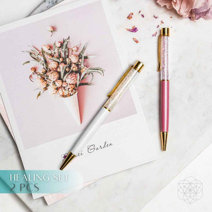 Pink crystal self-cleansing pen with gold barrel and cap, writing tip visible.
