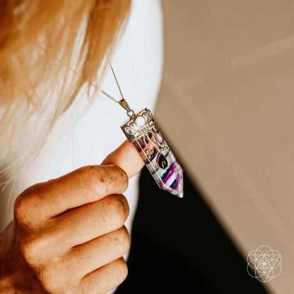 Silver necklace pendant with purple-blue crystal stripe design near the neckline