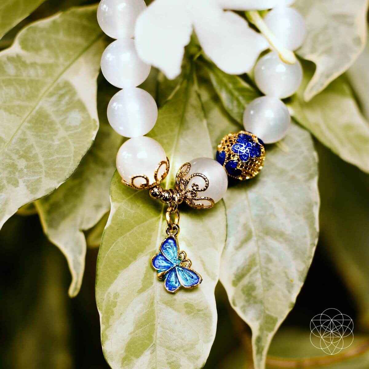 White bead spiritual growth bracelet with blue butterfly charm and gold filigree accents