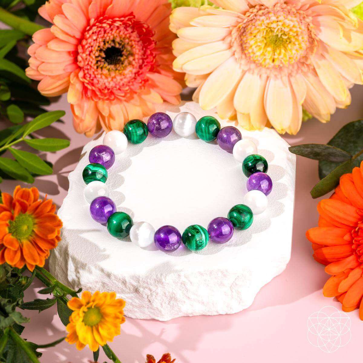 Beaded healing bracelet with green, purple, and white round beads forming a circle