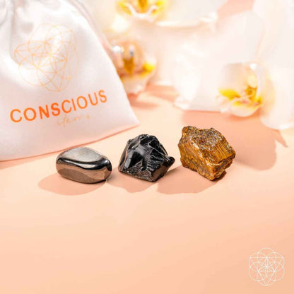 White pouch with orange print plus three protection stones: black, dark gray, gold-brown.