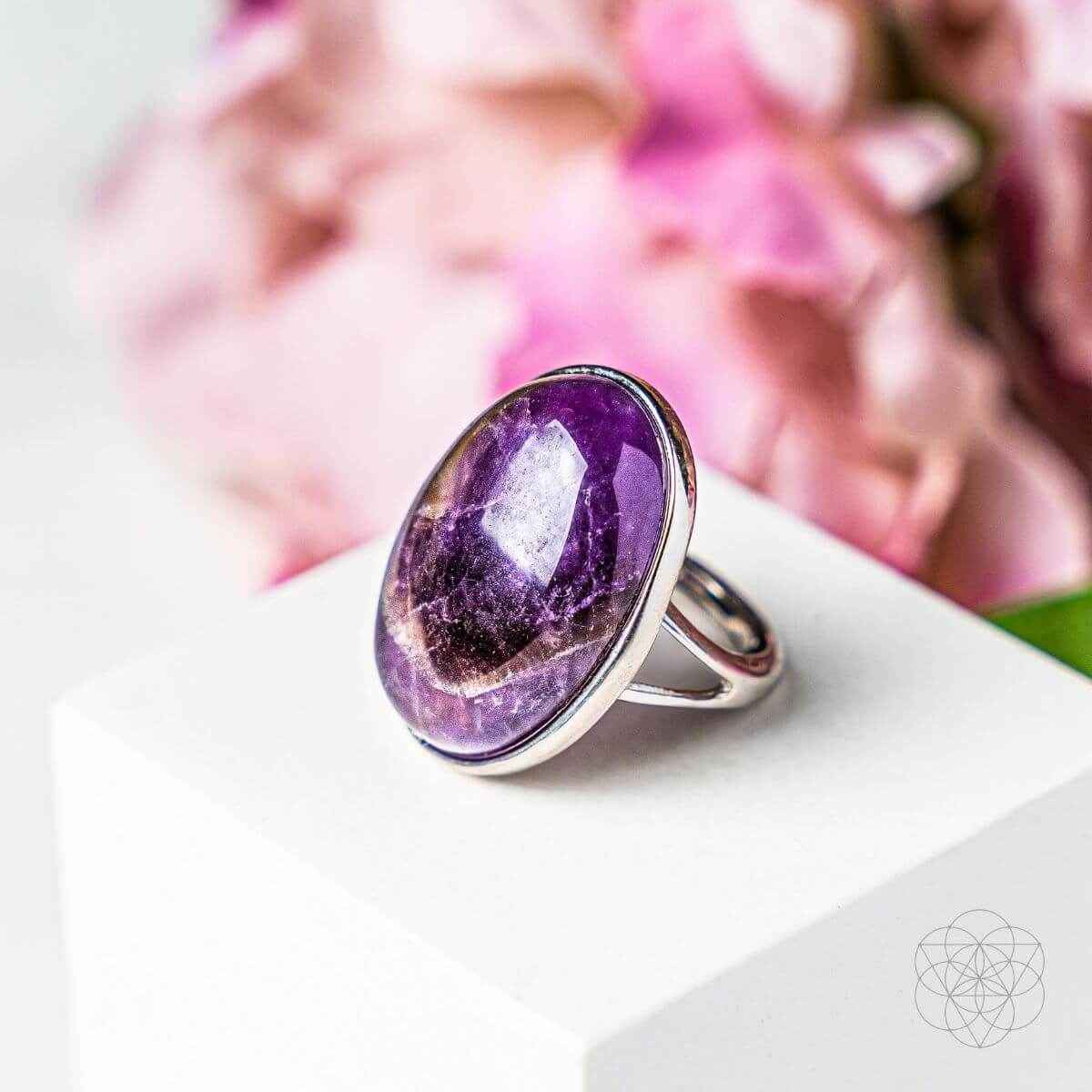 Silver ring with oval purple gemstone, polished bezel setting