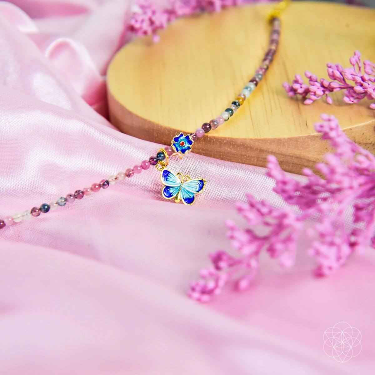 Beaded anklet with blue butterfly charm and small blue flower center detail
