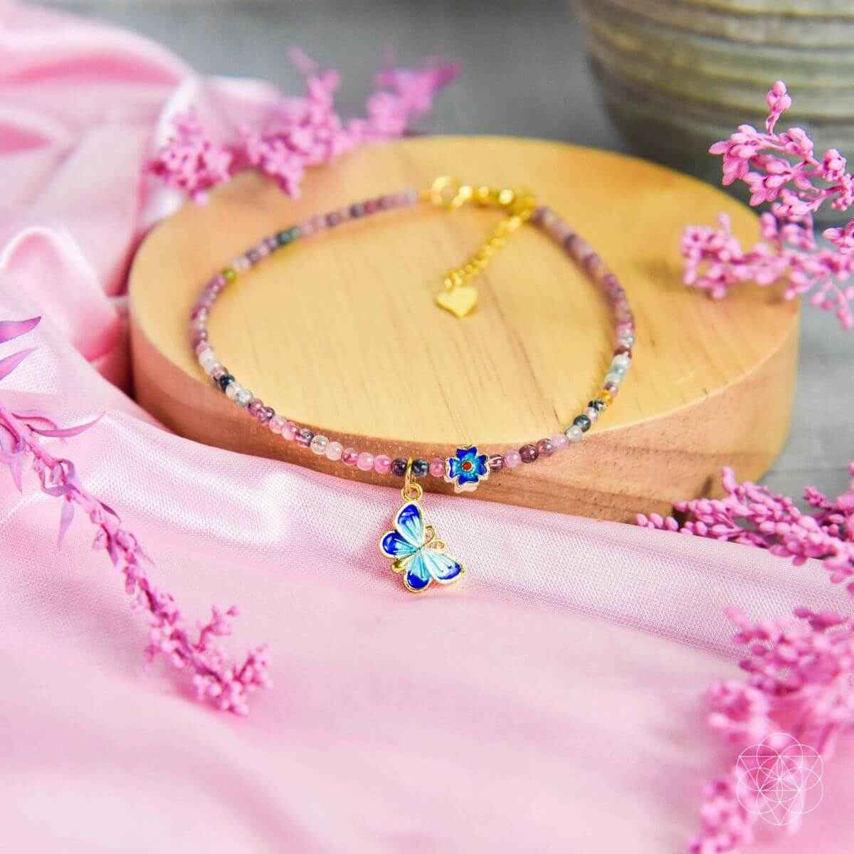 Beaded anklet with multicolor stones and a blue butterfly charm centerpiece
