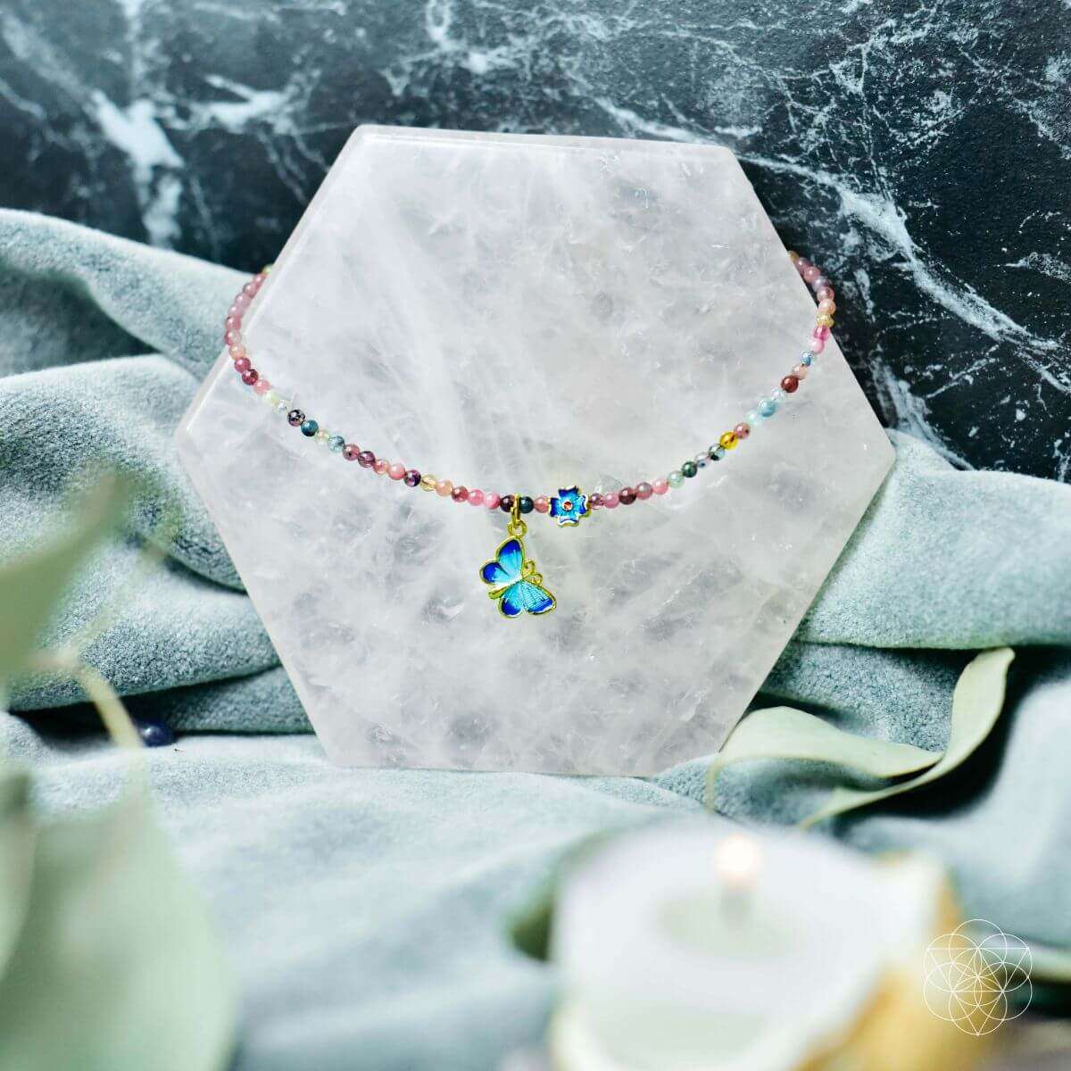 Multicolor beaded anklet on stand with blue butterfly charm and blue flower accents