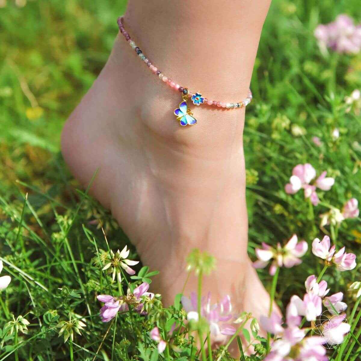 Blue-stone beaded anklet on ankle with a dangling blue butterfly charm