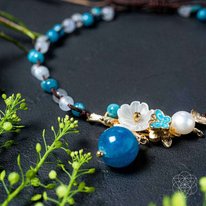Blue beaded anklet with gold butterfly clasp, pearl bead, and turquoise stones