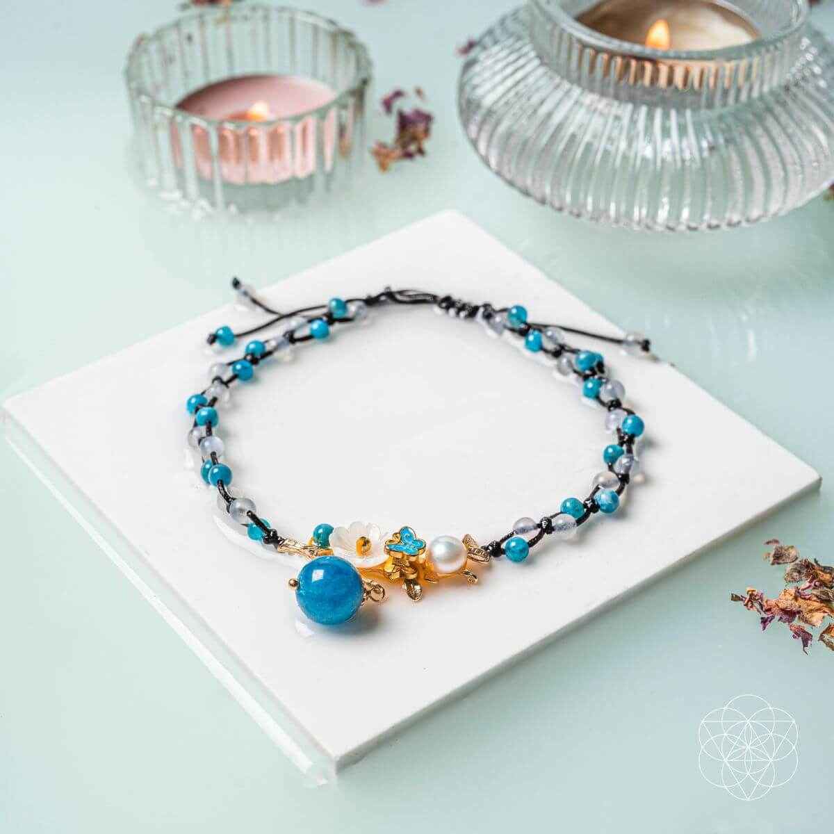 Blue beaded anklet with pearl charm and gold flower clasp