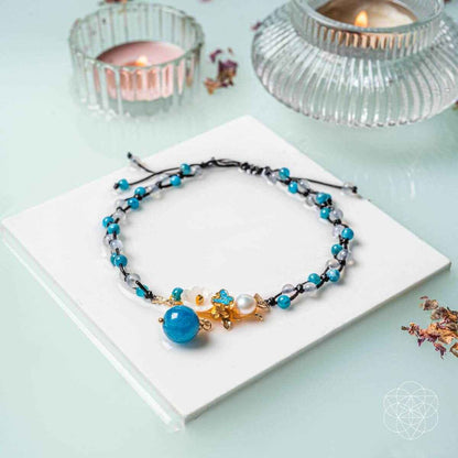 Blue beaded anklet with pearl charm and gold flower clasp