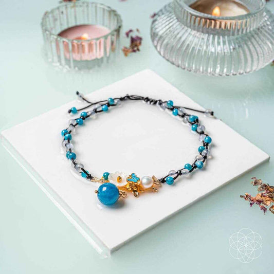 Blue beaded anklet with pearl charm and gold flower clasp