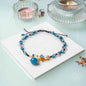 Blue beaded anklet with pearl charm and gold flower clasp