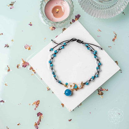 Blue beaded anklet on display card with round blue pendant