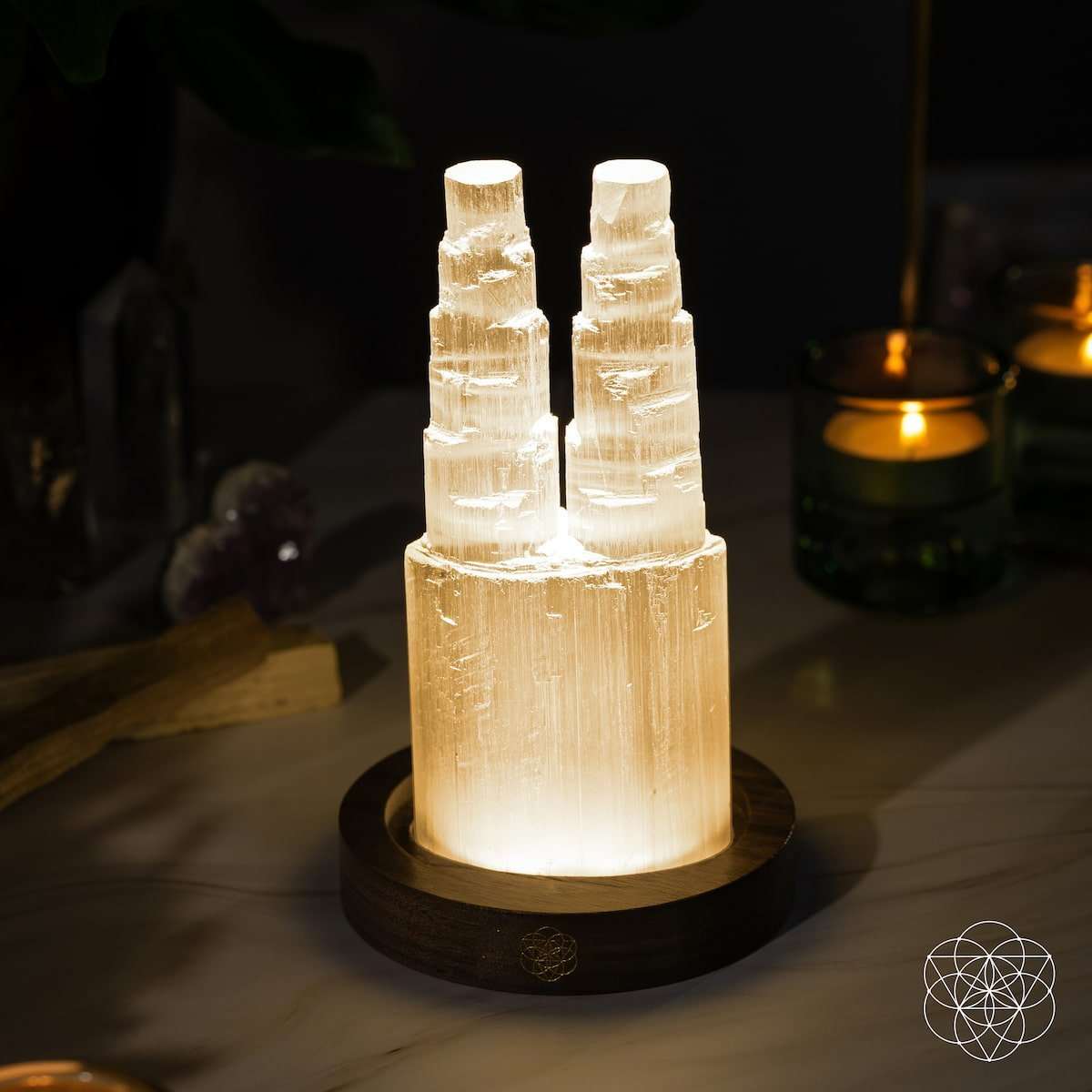 Two-tower selenite lamp with two warm golden glowing crystal columns on wooden base