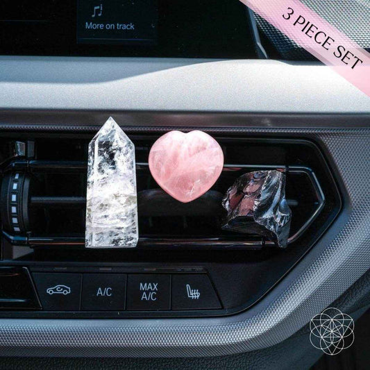Car crystal charm set in vent: clear crystal tower, pink heart, and dark wrapped charm