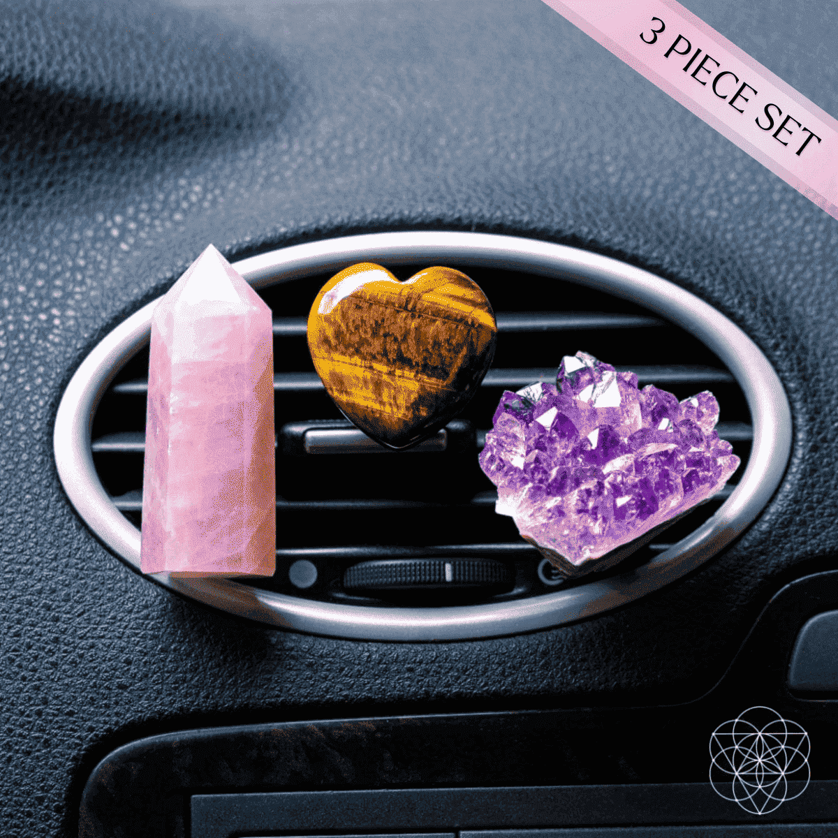Car crystal charm set close-up: pink crystal tower, gold heart, and purple geode in vent ring