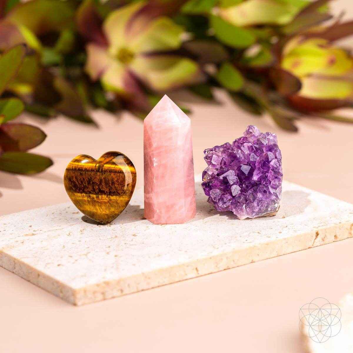 Car crystal charm set: pink tower, purple geode, and gold heart on a stone tray