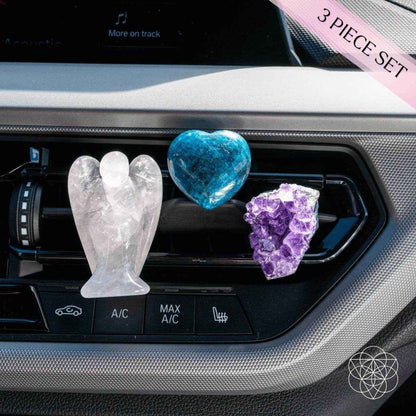 Car crystal charm set in vent: white angel figure, blue heart, and purple crystal cluster