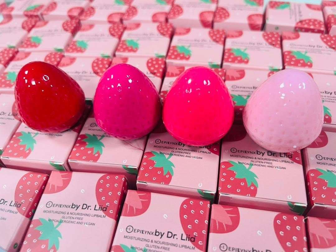 Strawberry-shaped lip butter containers in red and pink with product boxes.