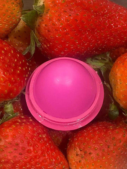 Pink strawberry-shaped lip butter container with lid open.