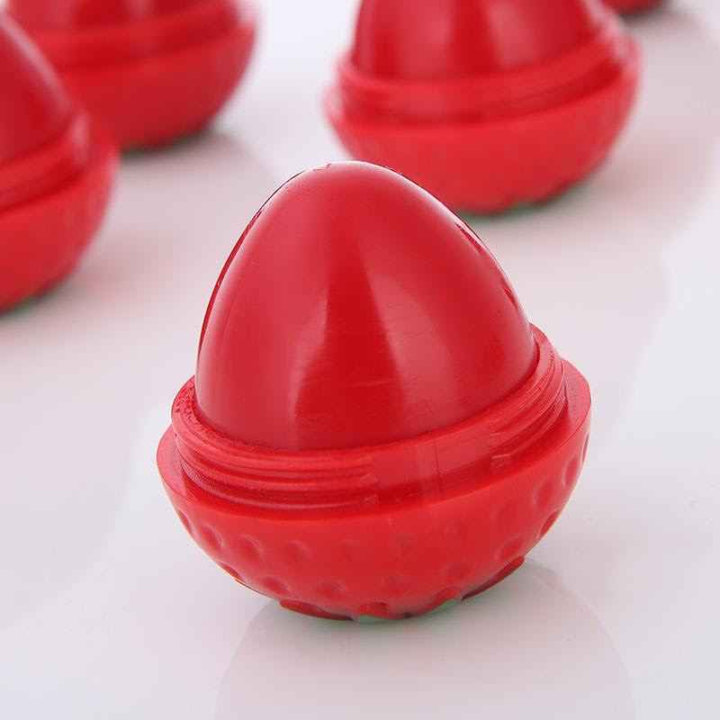 Red strawberry-shaped lip butter balm with domed cap and open base, glossy finish